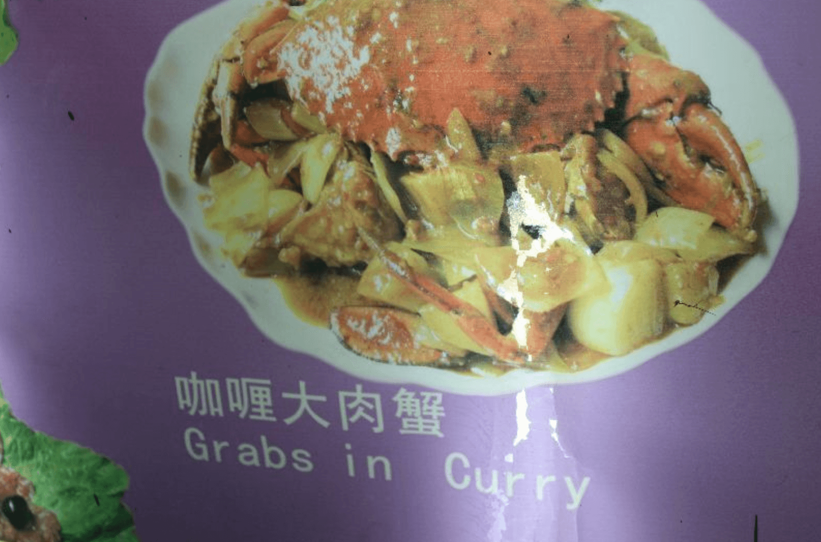Printed menus patched with stickers alongside an outdated translated version